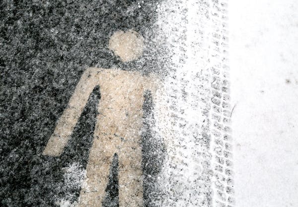 A pedestrian symbol on a trail in Loring Park is encrusted in ice Tuesday, Feb. 10, 2015 in Minneapolis, MN.
