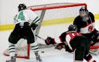 Hill-Murray's Mikey Anderson (24) scores a first period goal past Stillwater goalie Josh Benson (30) in the 2A boys' hockey section final Friday, Feb.
