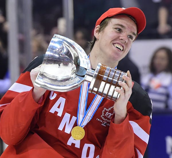 Canada's Connor McDavid skates with the trophy following his team's 5-4 win over Russia in the title game at the hockey World Junior Championship in T