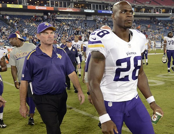 Mike Zimmer and Adrian Peterson didn’t have many opportunities to walk off the field together after a game in 2014 — here, after beating the Titan
