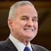 Gov. Mark Dayton smiled as he entered the press conference to talk about the budget surplus Friday.