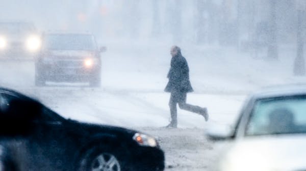 People walked, ran and pedaled through downtown Minneapolis during a Feb. 10 storm, as ice pellets turned to blowing snow.