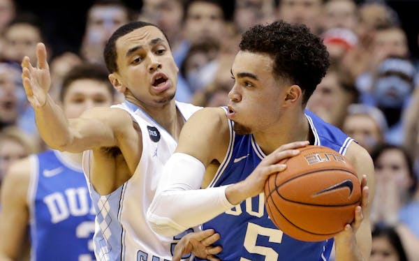North Carolina's Marcus Paige, left, guards Duke's Tyus Jones (5) during the first half of an NCAA college basketball game Saturday, March 7, 2015 in 