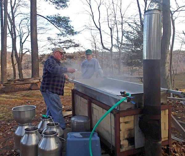 John Weyrauch, left, and John Miller began cooking about 425 gallons of maple sap Thursday morning, a long process.