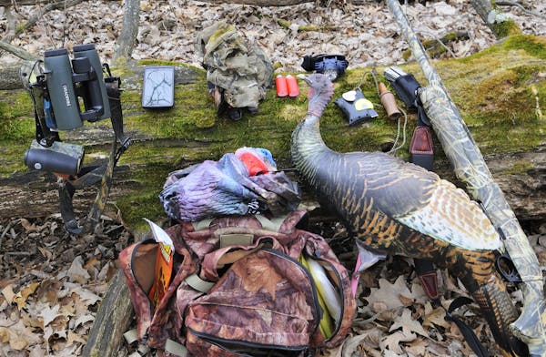 Hunting gear includes shotgun, calls, binoculars, headlamp, facemask, cell phone, decoys and backpack.