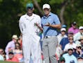 Jordan Spieth and his caddie, Michael Greller, talk about his shot on the 7th green during the third round of the Masters at Augusta National Golf Clu