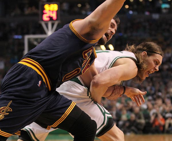 Cleveland Cavaliers forward Kevin Love (0) is dragged by the arm by Boston Celtics center Kelly Olynyk (41) during the first quarter of a first-round 