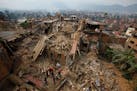 Rescue workers remove debris as they search for victims of earthquake in Bhaktapur near Kathmandu, Nepal, Sunday, April 26, 2015. A strong magnitude e