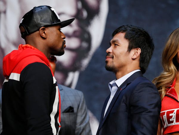 Floyd Mayweather Jr., left, and Manny Pacquiao pose for photographers during a news conference Wednesday, April 29, 2015, in Las Vegas. Mayweather wil