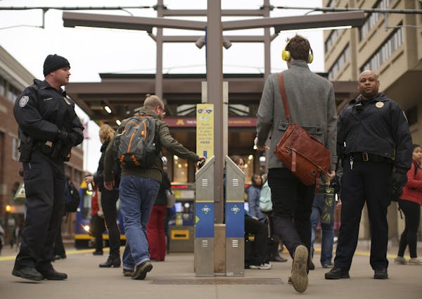 Transit officers Noah LaBathe, left, and LaFayette Temple checked for valid passes or receipts from riders at the East Bank Station in Minneapolis in 