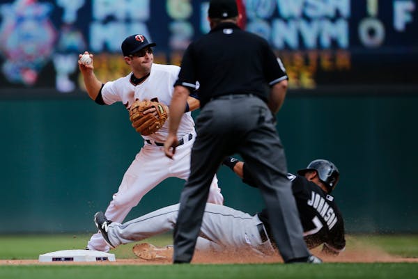 Twins second baseman Brian Dozier tags out White Sox infielder Micah Johnson before trowing the ball to Kennys Vargas at first for a double in the sev