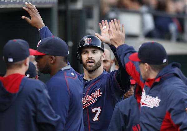 Minnesota Twins' Joe Mauer (7) celebrates scoring on a Trevor Plouffe triple in the third inning of a baseball game against the Detroit Tigers on Wedn