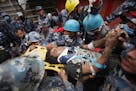 Pemba Tamang is carried on a stretcher after being rescued by Nepalese policemen and U.S. rescue workers from a building that collapsed five days ago 