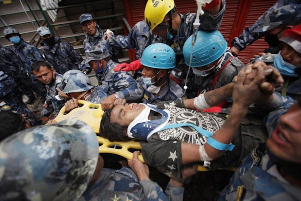 Pemba Tamang is carried on a stretcher after being rescued by Nepalese policemen and U.S. rescue workers from a building that collapsed five days ago 