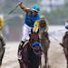 Jockey Victor Espinoza, center, celebrates aboard American Pharoah after winning the 140th Preakness Stakes horse race at Pimlico Race Course, Saturda