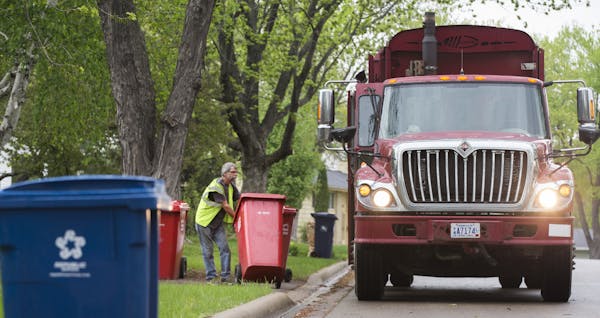 Patrick Cunningham with Burt’s Disposal emptied a garbage container into his truck in Bloomington. The city may switch from seven haulers to one.