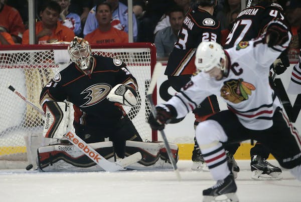 Anaheim Ducks goalie Frederik Andersen, left, reacts as the Chicago Blackhawks' Jonathan Toews, right, celebrates scoring a first-period power play go