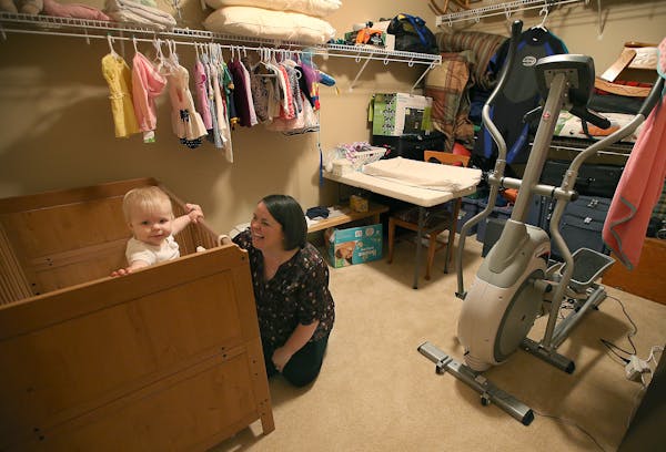 Sue Boxrud with daughter Lillie, 1, in a makeshift nursery. Boxrud and husband, Drew, are living with his parents while their new house in Lakeville i
