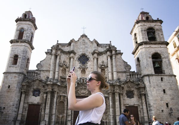Sarah Grimes, a violinist in the Minnesota Orchestra, takes photos in Plaza de la Catedral in Old Havana, Cuba on Wednesday.