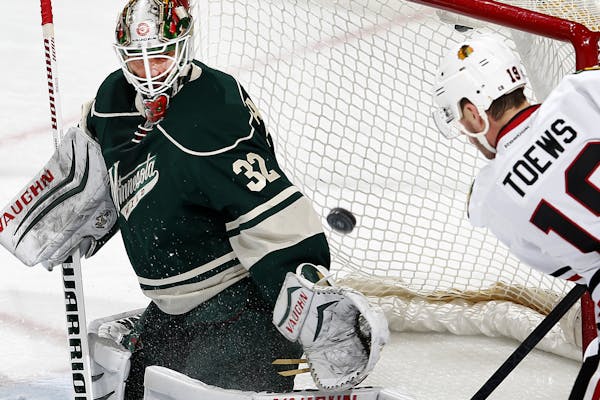 Minnesota Wild goalie Nicklas Backstrom (32) made a save against Jonathan Toews (19) in the first period.