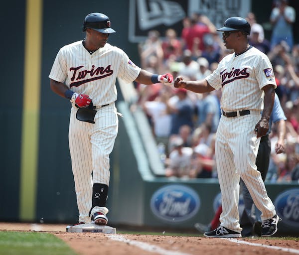Minnesota Twins right fielder Torii Hunter, left, (48) celebrates with first base coach Butch Davis (40) after hitting a two run single at Target Fiel