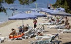 Tourists relax by the sea at Club Med in Grecolimano, Greece, on Friday, June 13, 2008. Club Mediterranee SA, Europe’s largest resort operator, repo