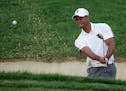 Tiger Woods hits out of a bunker on the 10th hole during the first round of the Memorial golf tournament Thursday, June 4, 2015, in Dublin, Ohio. (AP 