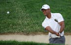 Tiger Woods hits out of a bunker on the 10th hole during the first round of the Memorial golf tournament Thursday, June 4, 2015, in Dublin, Ohio. (AP 