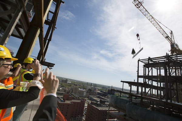 Invited guests watch and take photos from the 15th floor during a topping off ceremony for the new Wells Fargo towers by Ryan Companies in Minneapolis