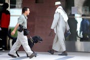 A Muslim cleric walks toward the courthouse for a pretrial hearing for three local men accused of conspiring to leave the country to support or join I