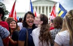 Supporters of same-sex marriage Pooja Mandagere, left, and Natalie Thompson kiss outside the U.S. Supreme Court following the announcement of the ruli