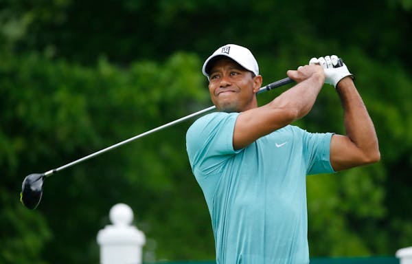 Tiger Woods watches his tee shot on the 12th tee during the first round of the Greenbrier Classic golf tournament at the Greenbrier Resort in White Su
