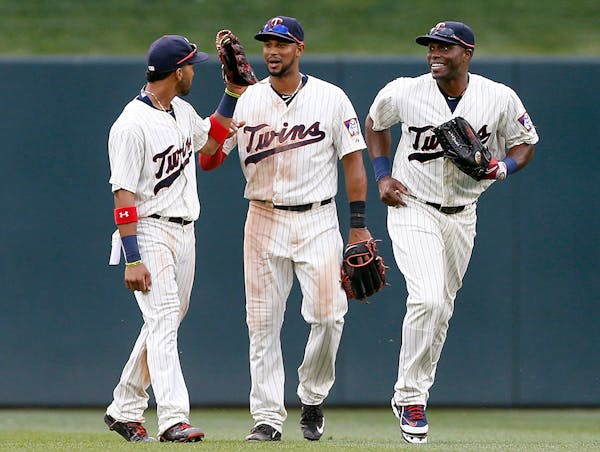 Eddie Rosario, Aaron Hicks and Torii Hunter celebrate their 9-5 win over the Detroit Tigers on Saturday.