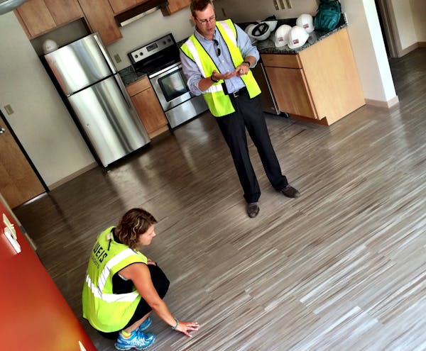 Architect Paul Mellblom and Gina Ciganik, with the nonprofit Aeon, inspected a soy-based floor material that is fully recyclable.