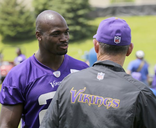 Vikings running back Adrian Peterson and coach Mike Zimmer, right, talked during minicamp last month at Winter Park. Zimmer believes Peterson’s pres