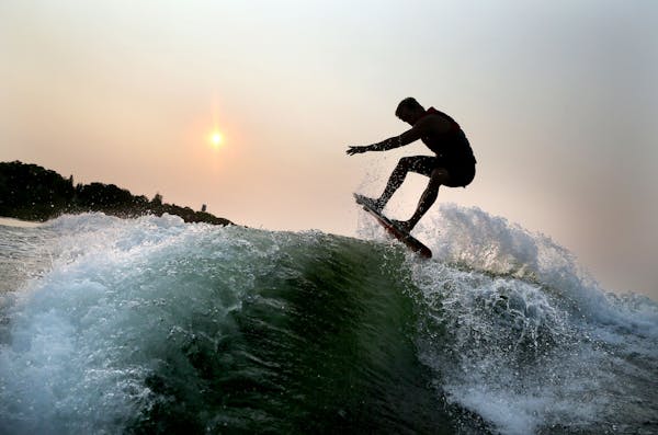 Pro wakeboard surfer Chris Banks practices wakeboard surfing on Lake Minnetonka near dawn.