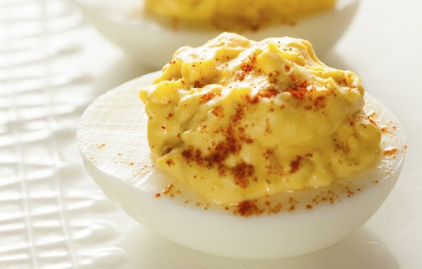 The traditional deviled egg, a favorite at any potluck gathering, is often topped with a sprinkle of paprika.