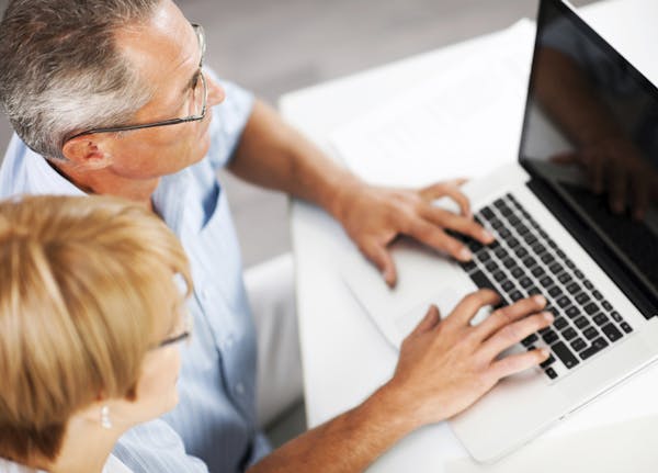 Above view of two businesspeople working on a laptop. The focus is on the man. [url=http://www.istockphoto.com/search/lightbox/9786622][img]http://dl.