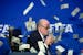FIFA president Sepp Blatter is photographed while banknotes thrown by British comedian Simon Brodkin hurtle through the air during a press conference 