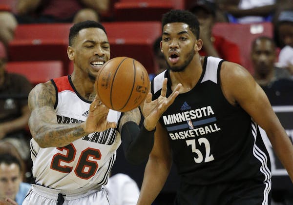 Portland Trail Blazers' Malcolm Thomas passes around Minnesota Timberwolves’ Karl-Anthony Towns during the first half of an NBA summer league basket