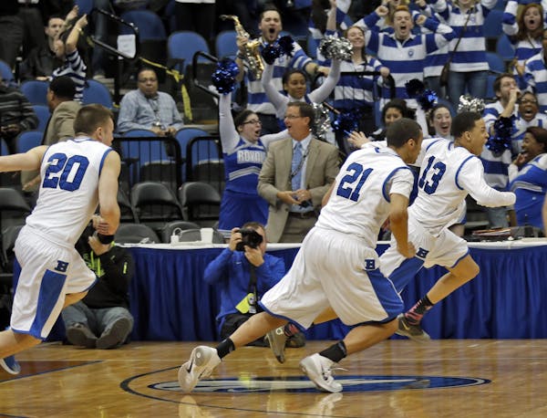 Hopkins Amir Coffey (13) led the victory celebration after hitting a half-court buzzer-beater in four overtimes during the 2014 Class 4A state tournam