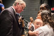 St. Paul Mayor Chris Coleman talks to M.K. Nguyen, holding her 2-month-old son Stokely Phan-Quang, and Maurice Hodges, top right, both residents of th