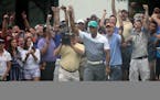 Tiger Woods reacts after holing out his chip shot on the 10th hole during the first round of the Wyndham Championship golf tournament in Greensboro, N