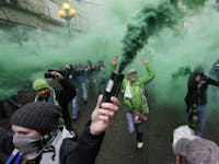 Members of the Emerald City Supporters burn smoke devices as they take part in the traditional "March to the Match" before the Seattle Sounders face S