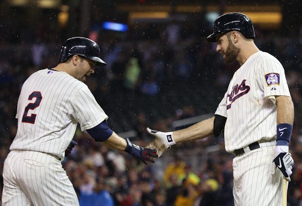 Brain Dozier celebrated with Joe Mauer after hitting a home run to lead off the fourth inning. Mauer then doubled to help continue the four-run outbur