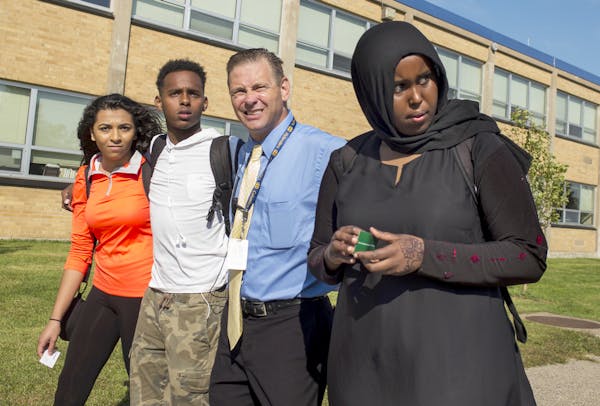 From left, Sherouk Mohamed, Karim Muse, Principal Dan Wrobleski and Khadra Mohamed returned to Columbia Heights High School after a protest.