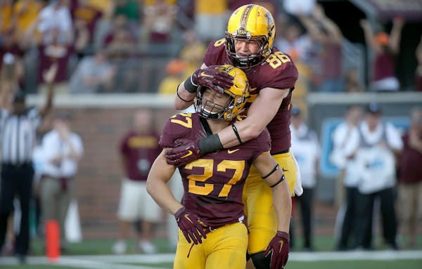 Minnesota's running back Shannon Brooks is congratulated by teammat Minnesota's tight end Brandon Lingen after he ran the ball into the end zone for a