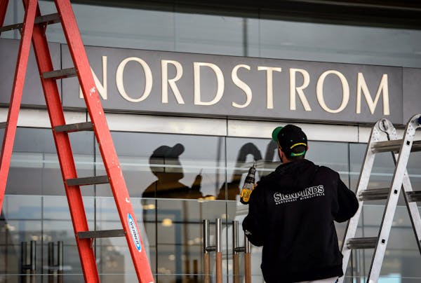 A worker puts up a sign over the door at the new Nordstrom store at Ridgedale in Minnetonka.