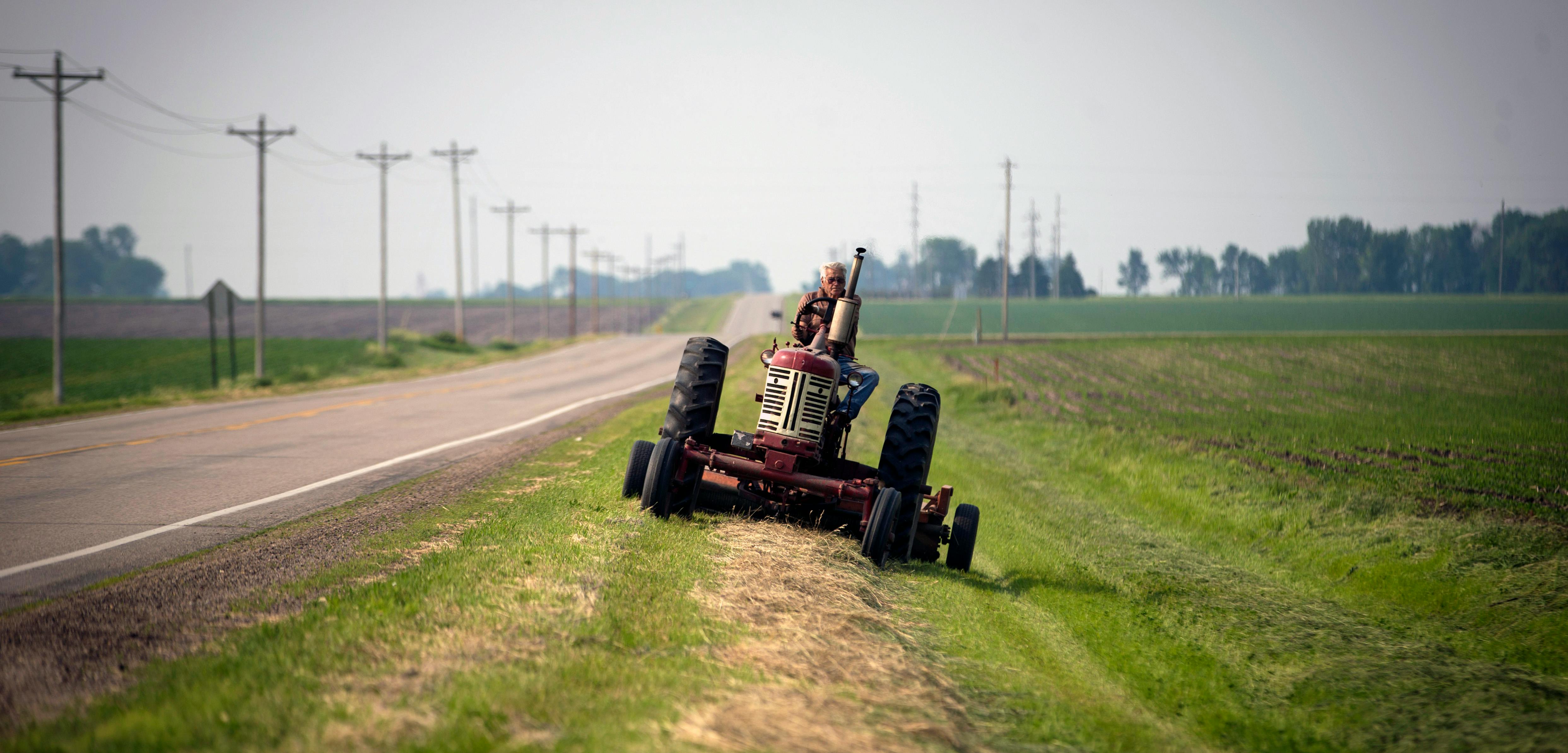 A farmer mowed the ditch around his crops near New Richland, Minn., on an old tractor. The U.S. doesn't require safety updates, even though rollover protection would greatly reduce the danger posed by vintage machines.
