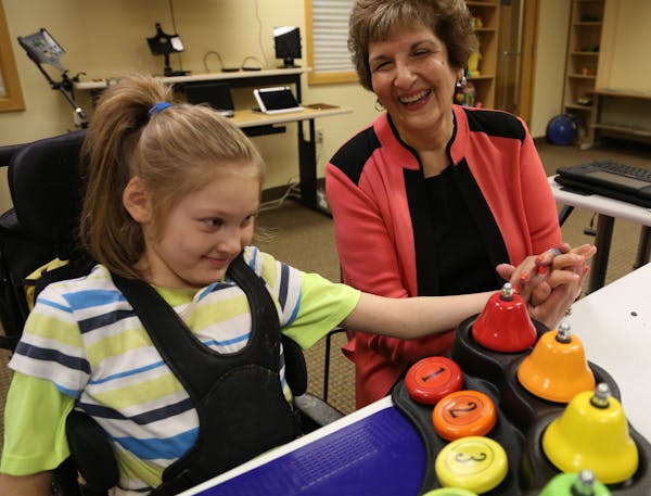 Paula Goldberg lent a helping hand to Amanda Larson, 8, of Houston, Minn., as she played with bells at the PACER Center in Bloomington. Goldberg co-fo